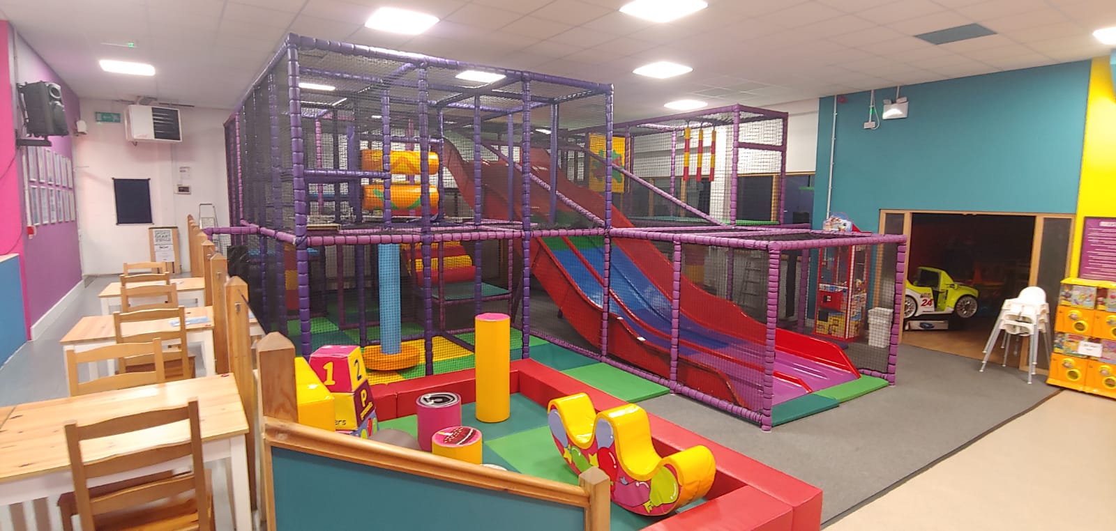 A play area featuring a slide, and play mats, designed for children.