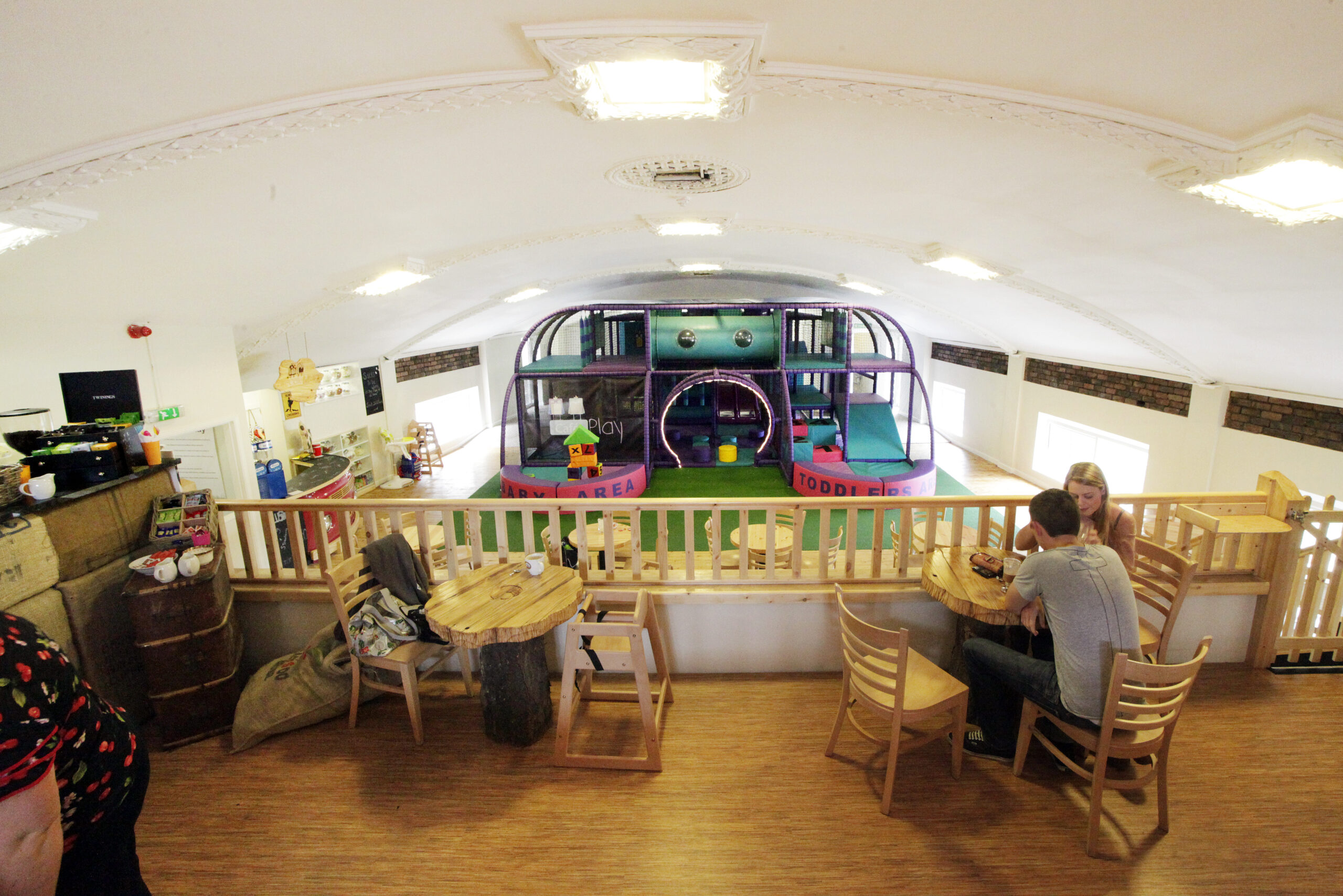 A play area and cafe scene with people at tables