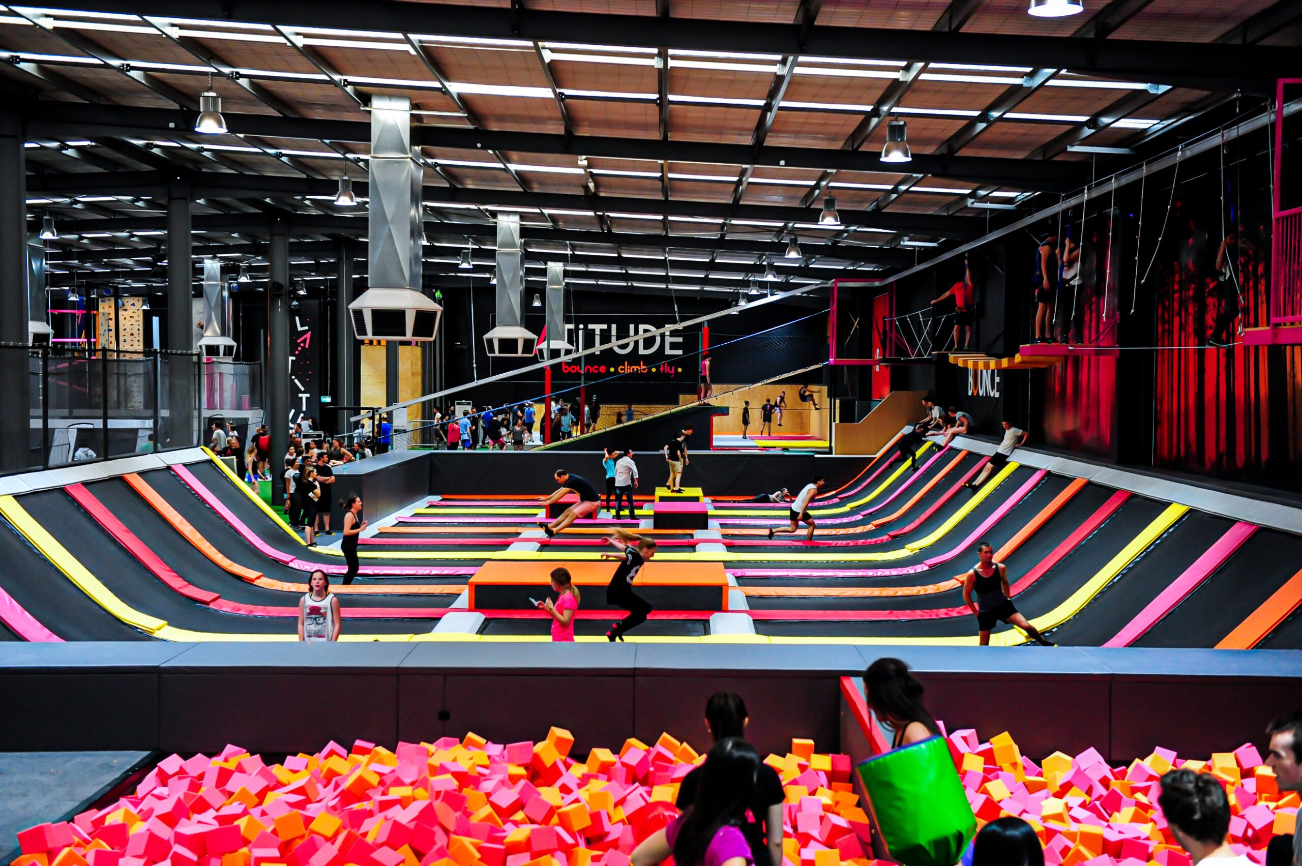 A large trampoline park, with a range of trampolines, mats and foam pits.