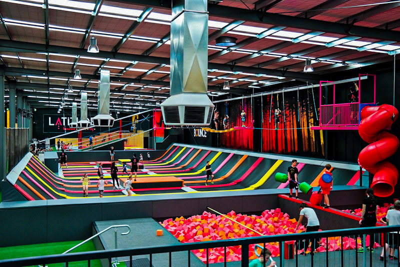 A large trampoline park, featuring a range of trampolines, mats and foam pits.