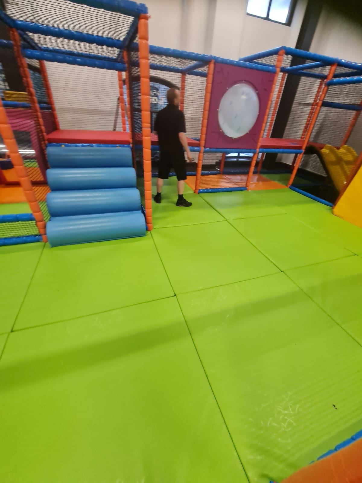 Play area with green mat and someone maintaining space